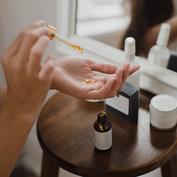 face serum dropping into had