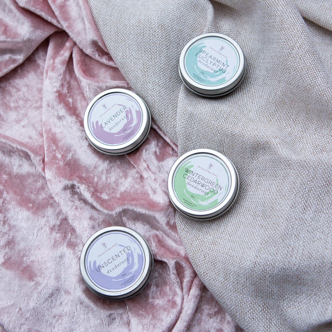 Charcoal and rose petals women’s deodorant collection on purple linen and velvet
