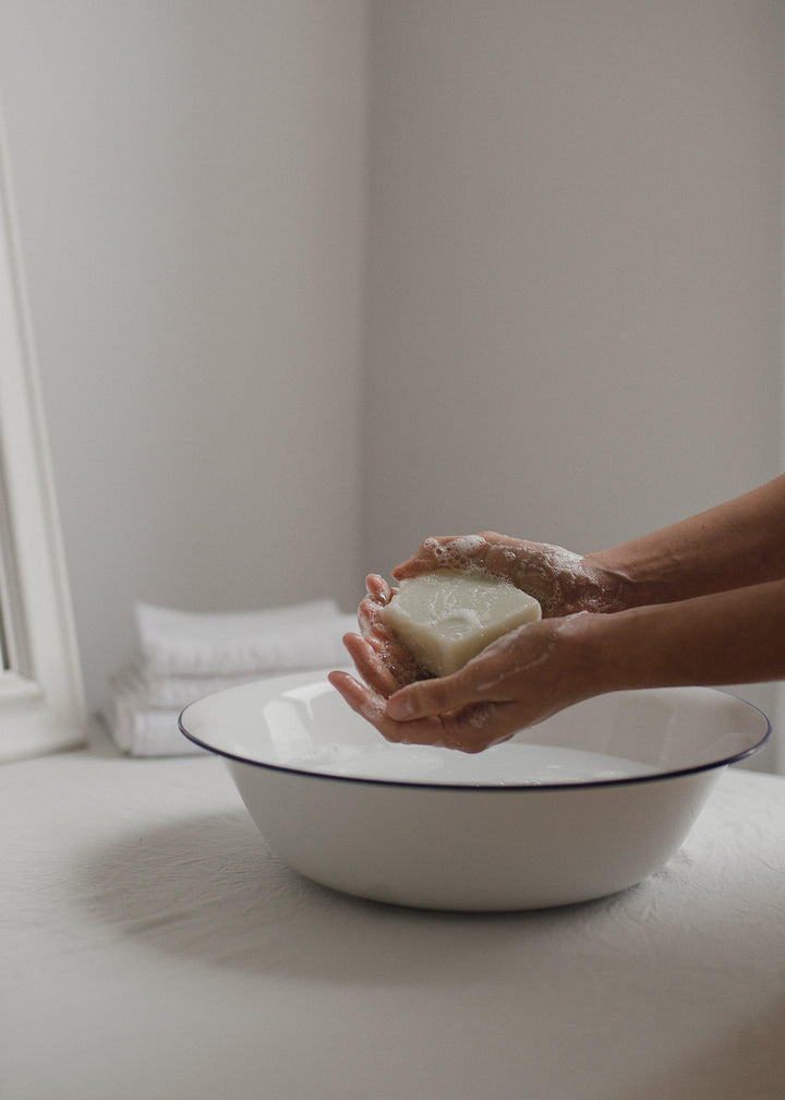 White Simple Soap hand & body bar being lathered over water bowl