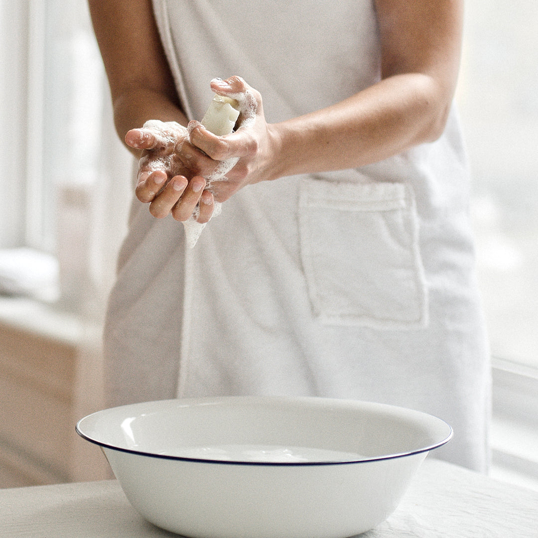 woman lathering Simple White Soap over bowl