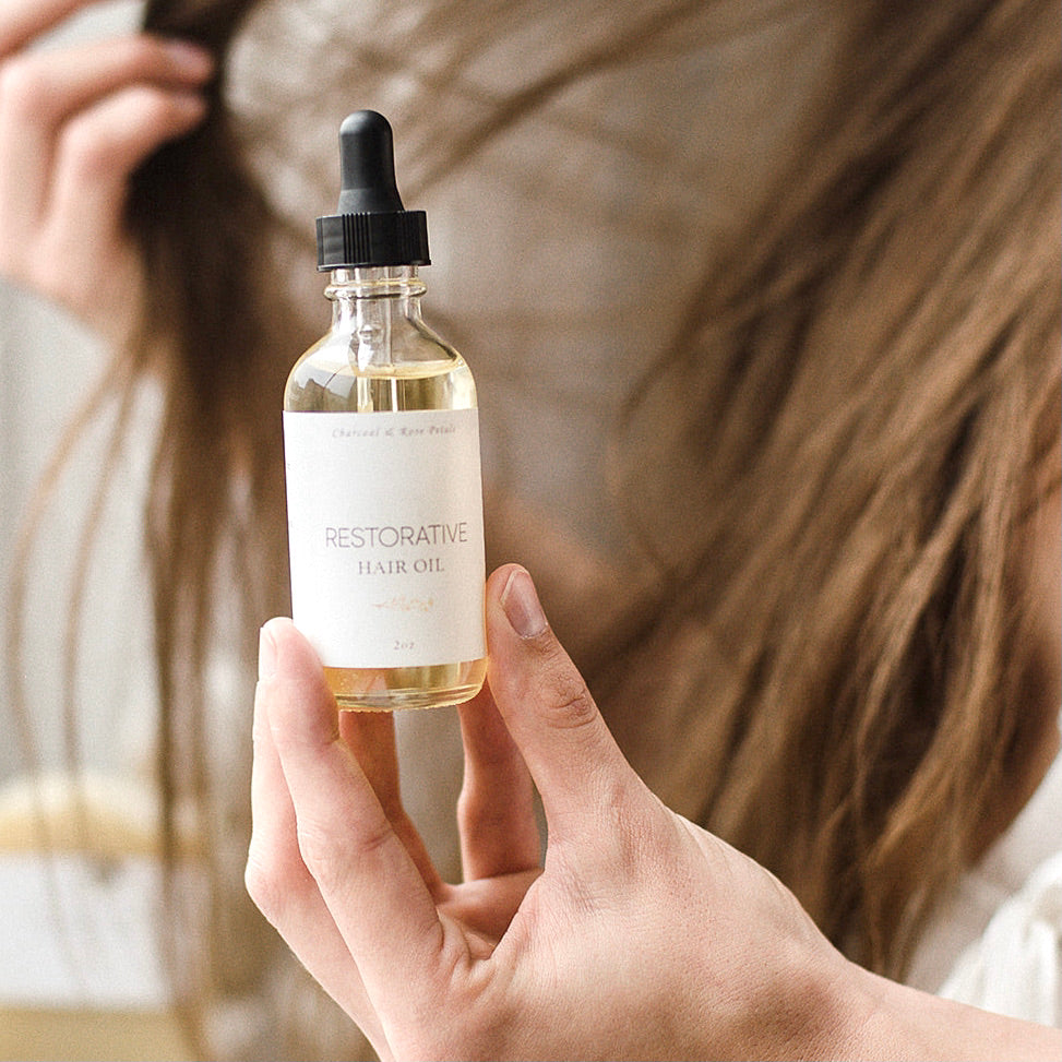 restorative hair oil in front of long hair
